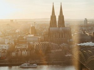 Foto der Kölner Innenstadt mit Dom und Rhein im Sonnenschein